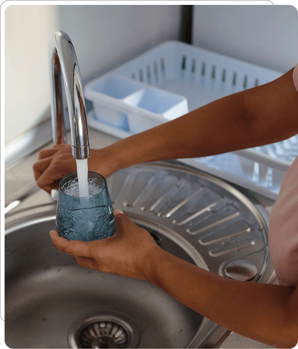 Filling glass with water at kitchen sink